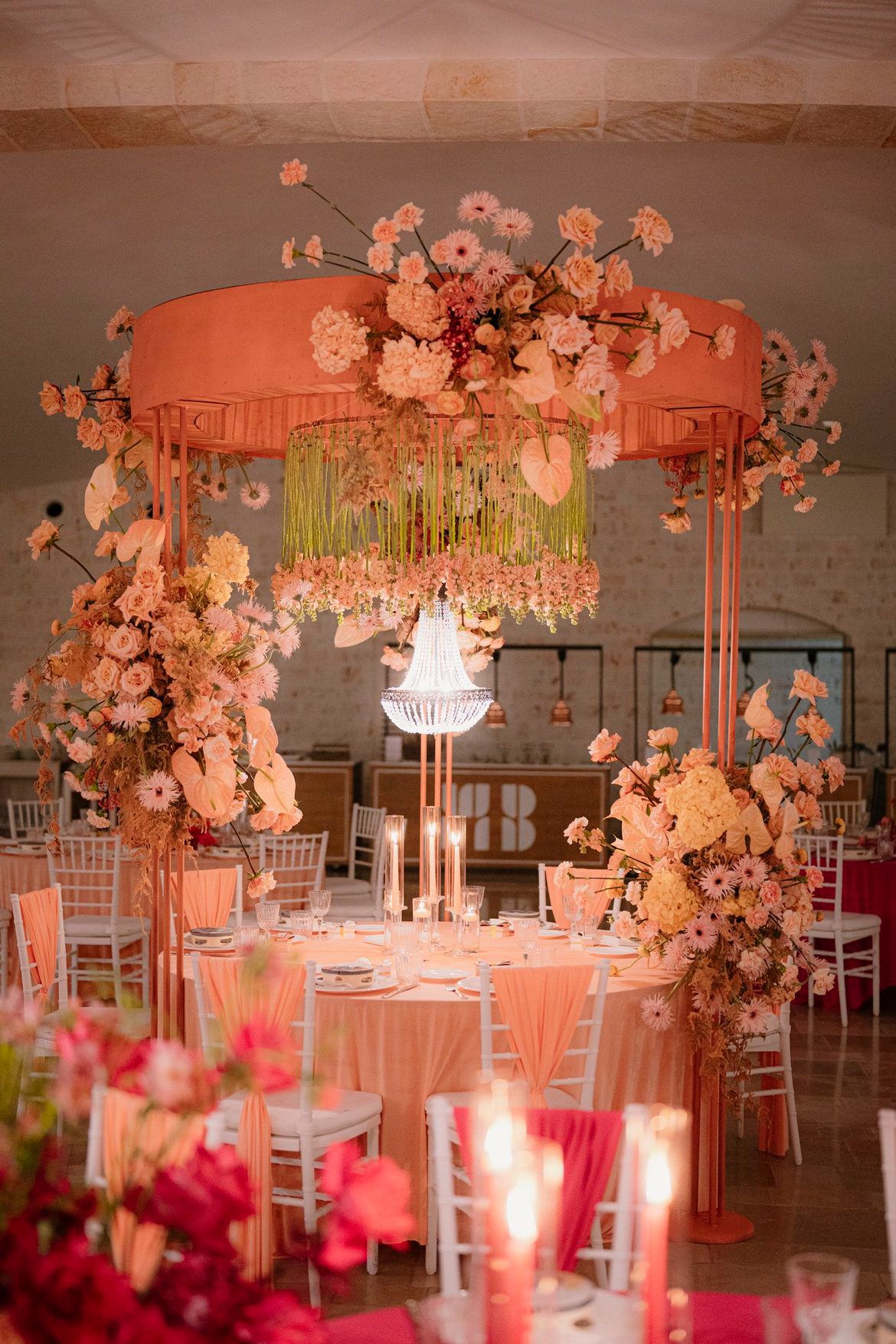 Centrotavola LIPPOLIS con rose pesca, anthurium e gerbere rosa su struttura metallica dorata